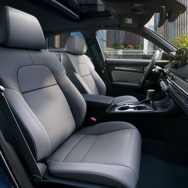 2027 Honda Civic Sedan Sport Touring Hybrid front seats and dashboard view in a city (Compact Sedan)